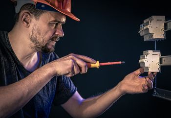 electricista con un destornillador trabajando en caja de fusibles